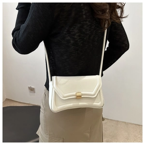 Detailed back view of minimalist white leather saddle bag with golden clasp worn by a model