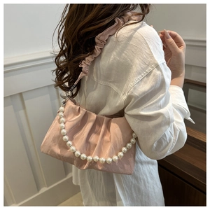 Detailed view of pink pleated cloud bag with pearl strap and fabric shoulder strap