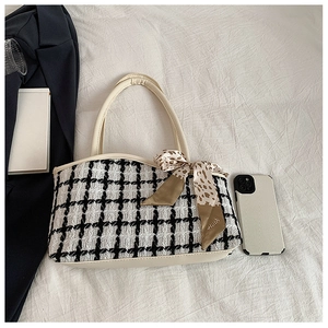 Detail of checkered tote bag with cream leather handles and leopard print silk scarf