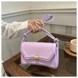 Detail of lavender PU leather saddle bag featuring golden metal clasp and knotted strap