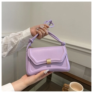 Close-up of light purple leather handbag with gold square lock and knotted strap detail