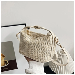 Detail of straw crossbody bag with cream PU trim and gold metal buckle closure