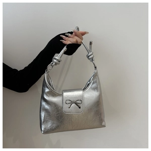 Détail du nœud argenté et de la poignée nouée sur le sac à main au fini métallisé