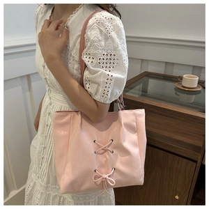 Close-up of pink tote bag featuring a decorative bow and stylish ribbon detail