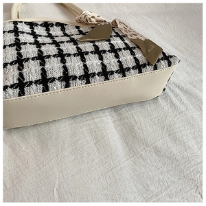 Close-up of houndstooth tweed tote bag with faux leather trim and leopard print scarf handle