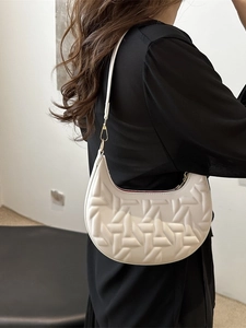 Minimalist white hobo bag with geometric woven texture shown on model's shoulder
