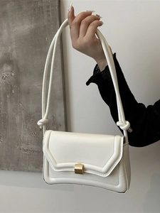 Minimalist white saddle shoulder bag with golden buckle and decorative knot details