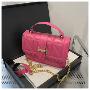 Detail of rose red quilted chain bag with gold metal buckle on elegant gift box