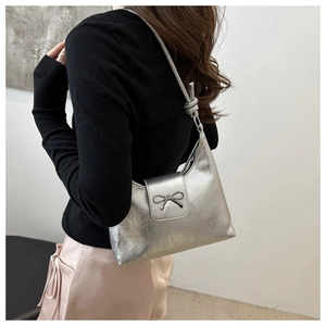 Vue détaillée du sac à bandoulière argenté avec boucle nœud en métal et sangle nouée
