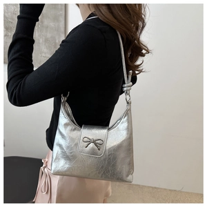 Détail du sac hobo argenté métallisé avec texture froissée et boucle nœud en métal