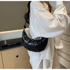 Detail of black crescent hobo bag showing natural leather texture and metal zipper