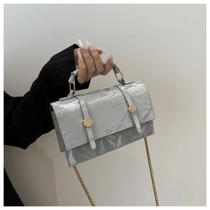 Detailed shot of textured silver marble pattern handbag with gold metal chain strap