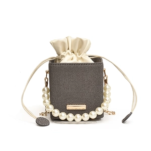 Taupe mini drawstring crossbody bag with large pearl handle and gold chain strap