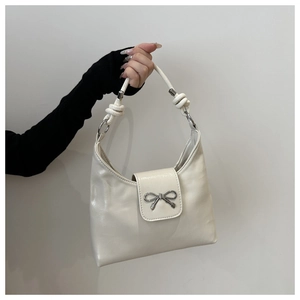 Détail du sac en cuir PU blanc crème avec nœud en métal argenté et bandoulière à nœuds