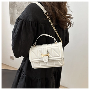 White quilted crossbody bag with gold H-buckle shown on model in side-back view