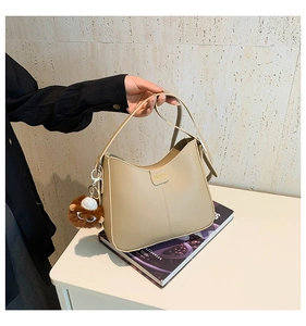 Detail of khaki hobo shoulder bag with smooth faux leather and cute lion plush charm