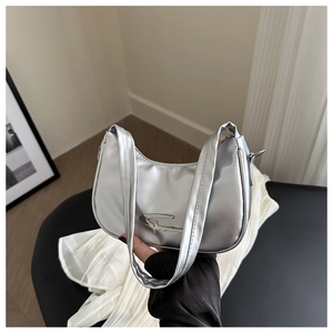 Detail der silbernen Metallic-Hobo-Tasche mit Sternen-Emblem und glatter Mond-Silhouette