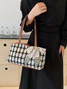 Tweed tote bag with brown leather handles and decorative floral scarf on a model