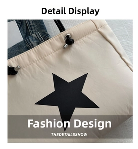 Detail of cream puffy tote bag showing drawstring closure and black star pattern