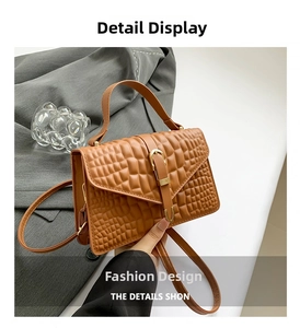Detail of premium brown crocodile embossed leather and golden buckle on small square bag