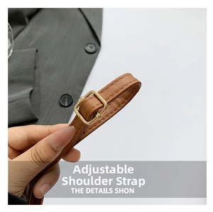 Detail of adjustable brown faux leather strap with golden metal buckle and stitching