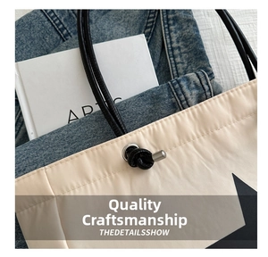 Detail of star print nylon tote bag featuring black leather handles and metal drawstrings