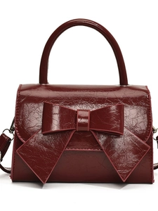 Deep burgundy bow handbag with glossy wrinkled texture and sturdy top handle