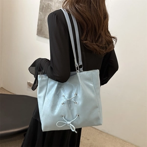 Light blue faux leather tote bag with lace-up bow detail and dual shoulder straps