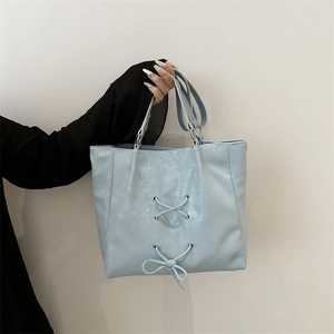 Light blue bow tote bag with cross-drawstring detail for casual commute