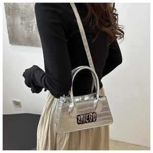 Silver crocodile pattern crossbody bag with ZMIEBO embroidery shown in a lifestyle shot