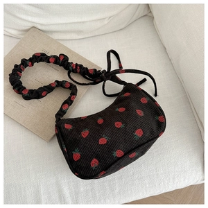 Detail of black corduroy shoulder bag with strawberry print and ruched strap