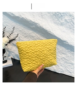 Detailed view of yellow quilted handbag featuring an intricate 3D floral stitched pattern