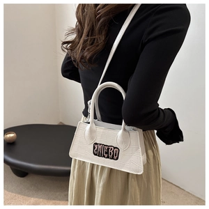 Detailed view of white crocodile pattern leather handbag with ZMIEBO embroidery patch