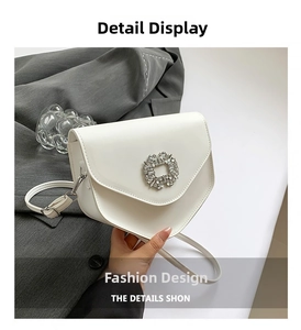 Détail du sac bandoulière blanc en similicuir avec une boucle sertie de cristaux