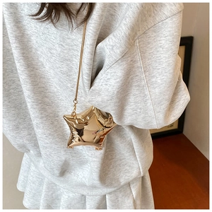 Detailed view of a metallic star-shaped mini bag with gold chain and pleated mirror finish