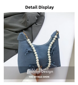 Detail of light blue denim tote with 3D bows and a large white pearl bead handle