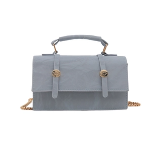 Light blue textured leather handbag with gold hardware and chain shoulder strap on white base