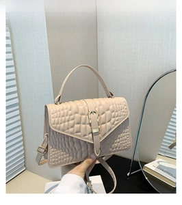 Detail of khaki crocodile pattern handbag with metal buckle and adjustable shoulder strap