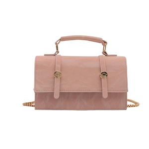 Sac sous le bras en cuir plissé rose avec chaîne dorée et poignée sur fond blanc
