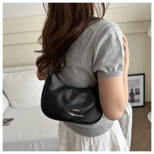 Detailansicht der schwarzen Halbmond-Tasche mit silbernem Metall-Logo für Damen