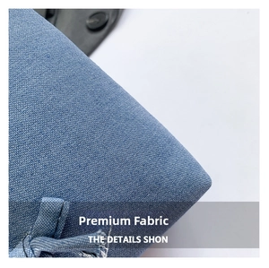 Close-up of premium blue denim fabric texture and stitching on the tote bag