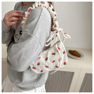 Detail of strawberry corduroy bag with scrunchie strap and side bow decoration