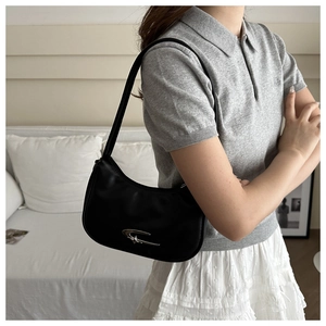 Nahaufnahme der minimalistischen schwarzen Hobo-Bag mit markantem silbernem Metall-Logo-Detail