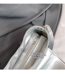 Detail of silver metallic bag with zip hardware and magnetic closure mechanism