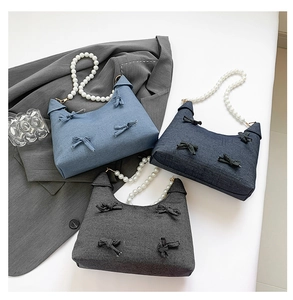 Three bow-knot denim tote bags in blue and grey with elegant white pearl handles