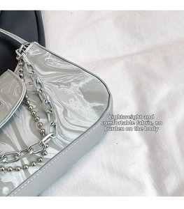 Detail of silver marble texture bag with metallic chain and pearl strap hardware