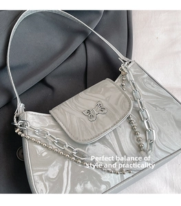 Close-up of silver crescent bag with butterfly buckle and marble water ripple texture