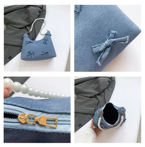 Detail view of denim crescent bag with bow decoration and white pearl chain handle