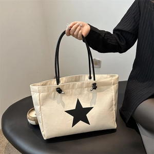 Cream tote bag with black star print and rope shoulder straps for stylish daily commuting