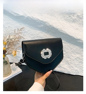 Détail du sac noir avec rabat en V et boucle scintillante en strass cristal